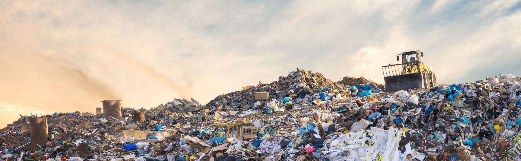 JCB on top of a mountain of waste at a landfill site